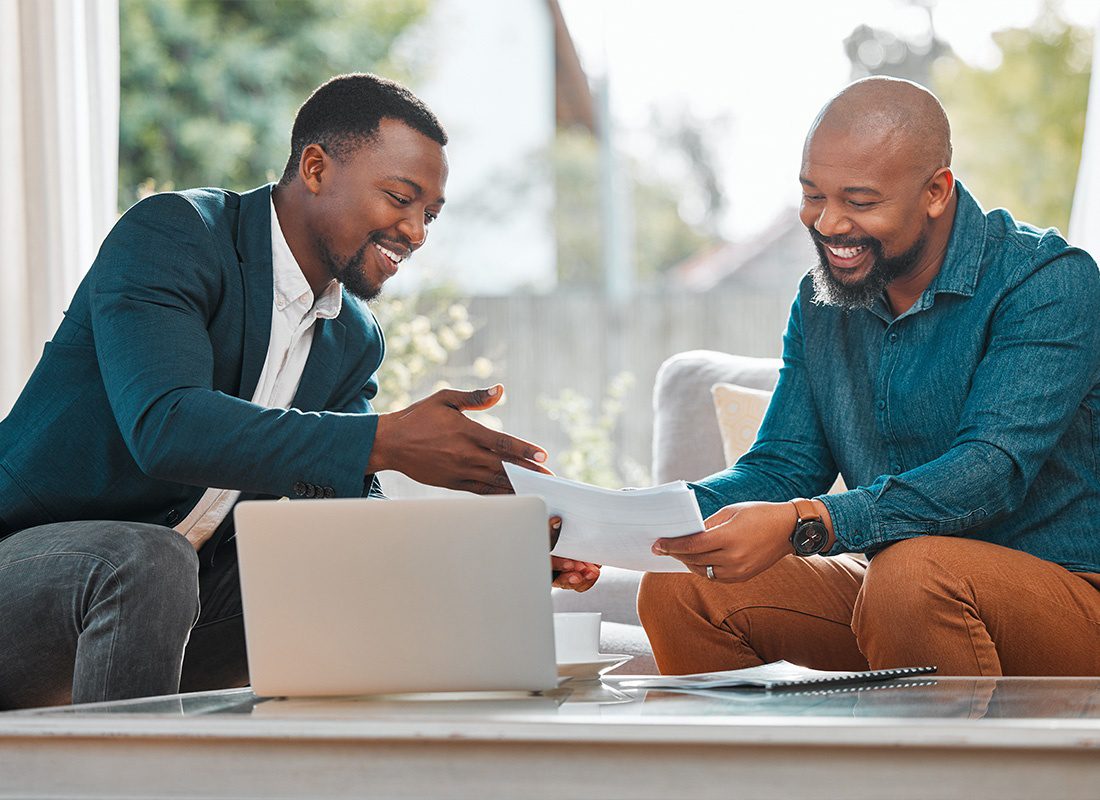 Risk Consultation - Two Young Men Having a Conversation While Looking at Papers